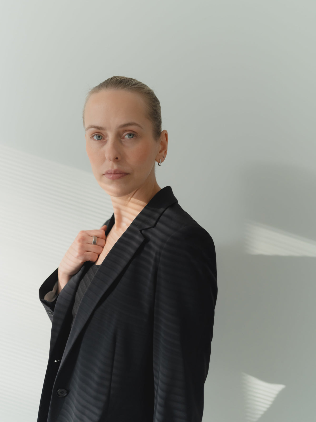 A women portrait in a black ultra-light women’s power stretch performance blazer in stretch technical fabric with notch lapel. Single breasted, regular fit.