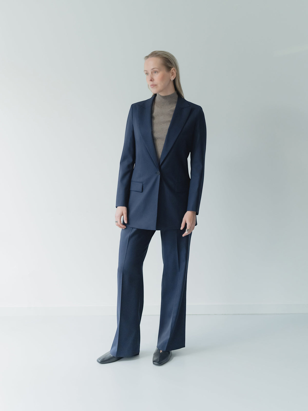 Person wearing a navy blue suit on a white background