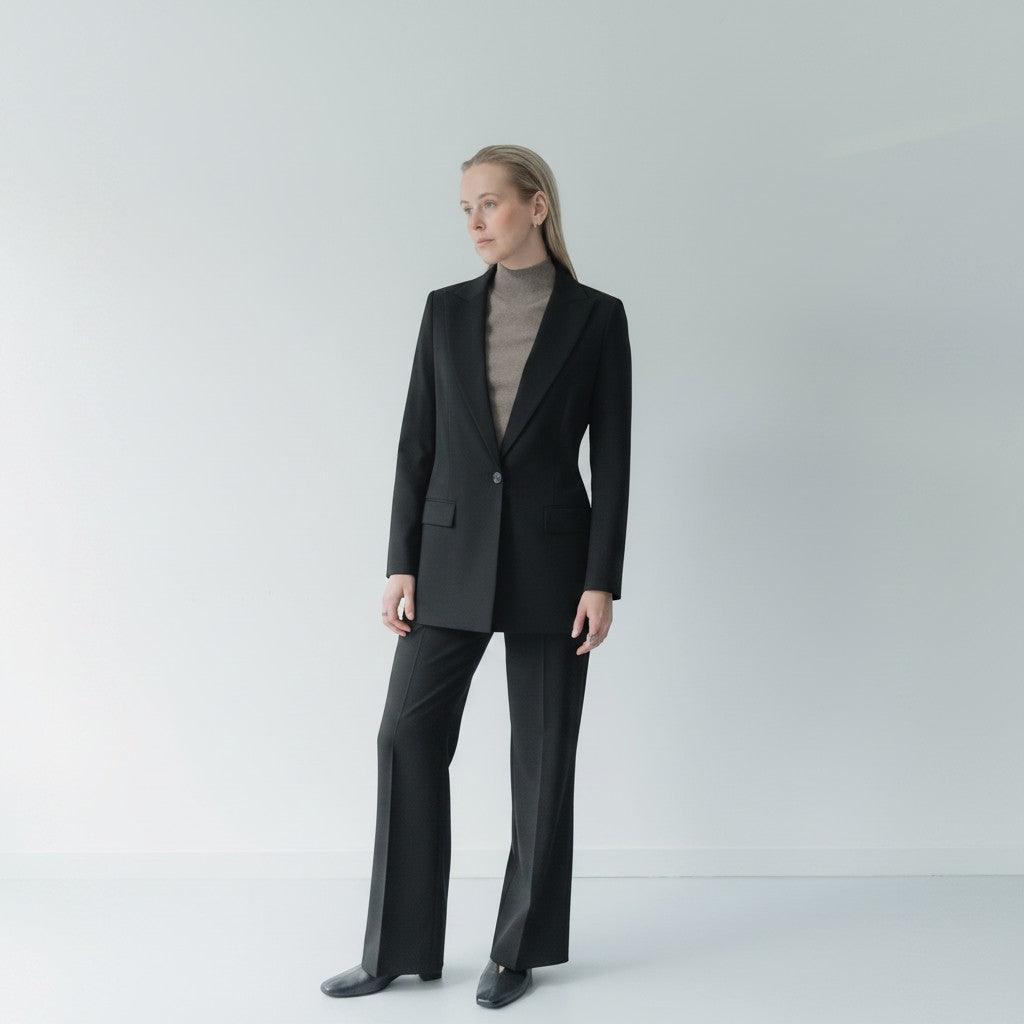 NOVEM STUDIO navy blue wool blend stretch serge suit with peak lapel blazer and straight-leg trousers worn by a woman.
