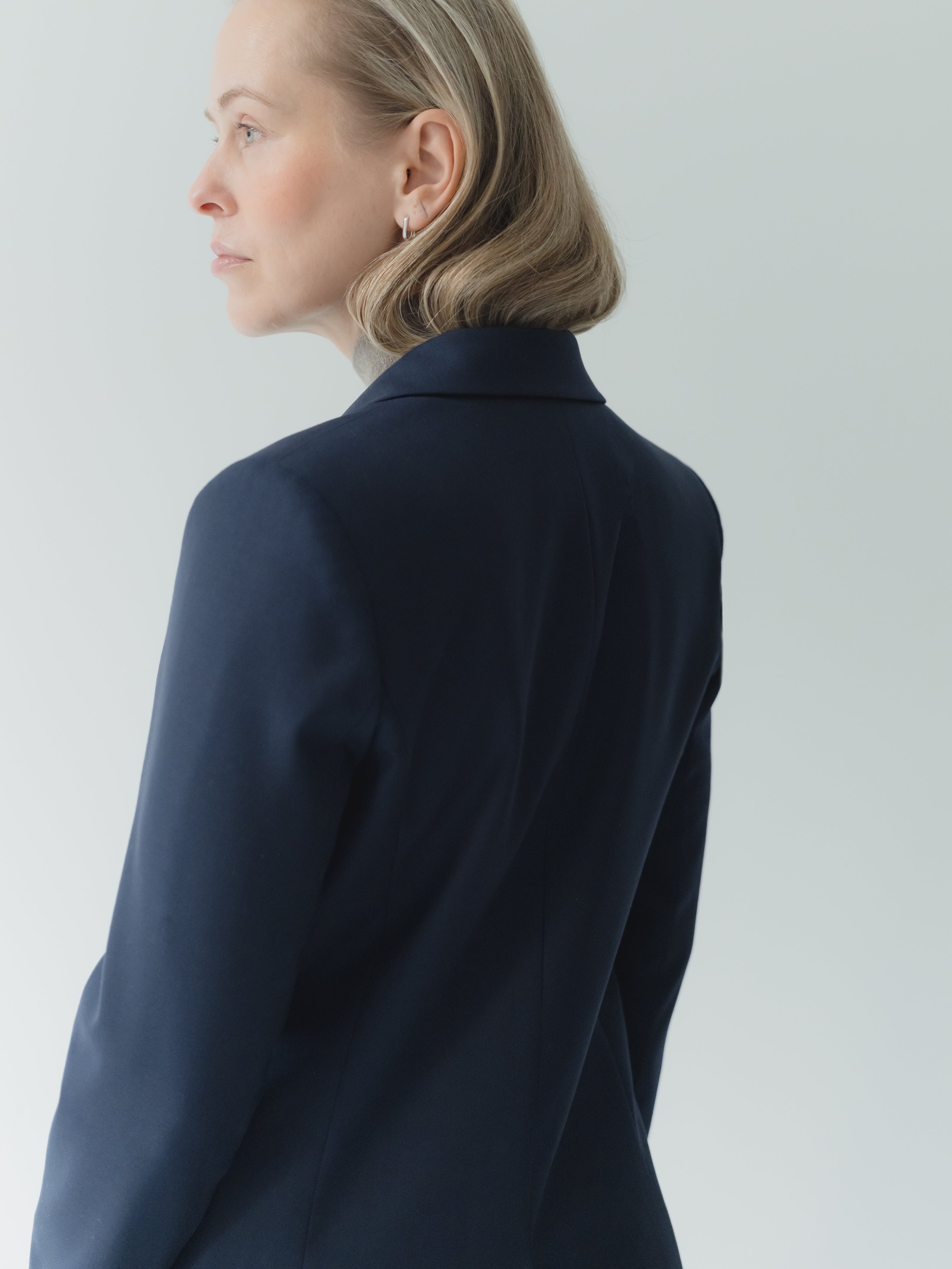 Navy single-breasted women’s peak lapel blazer in mid-weight stretch serge wool.