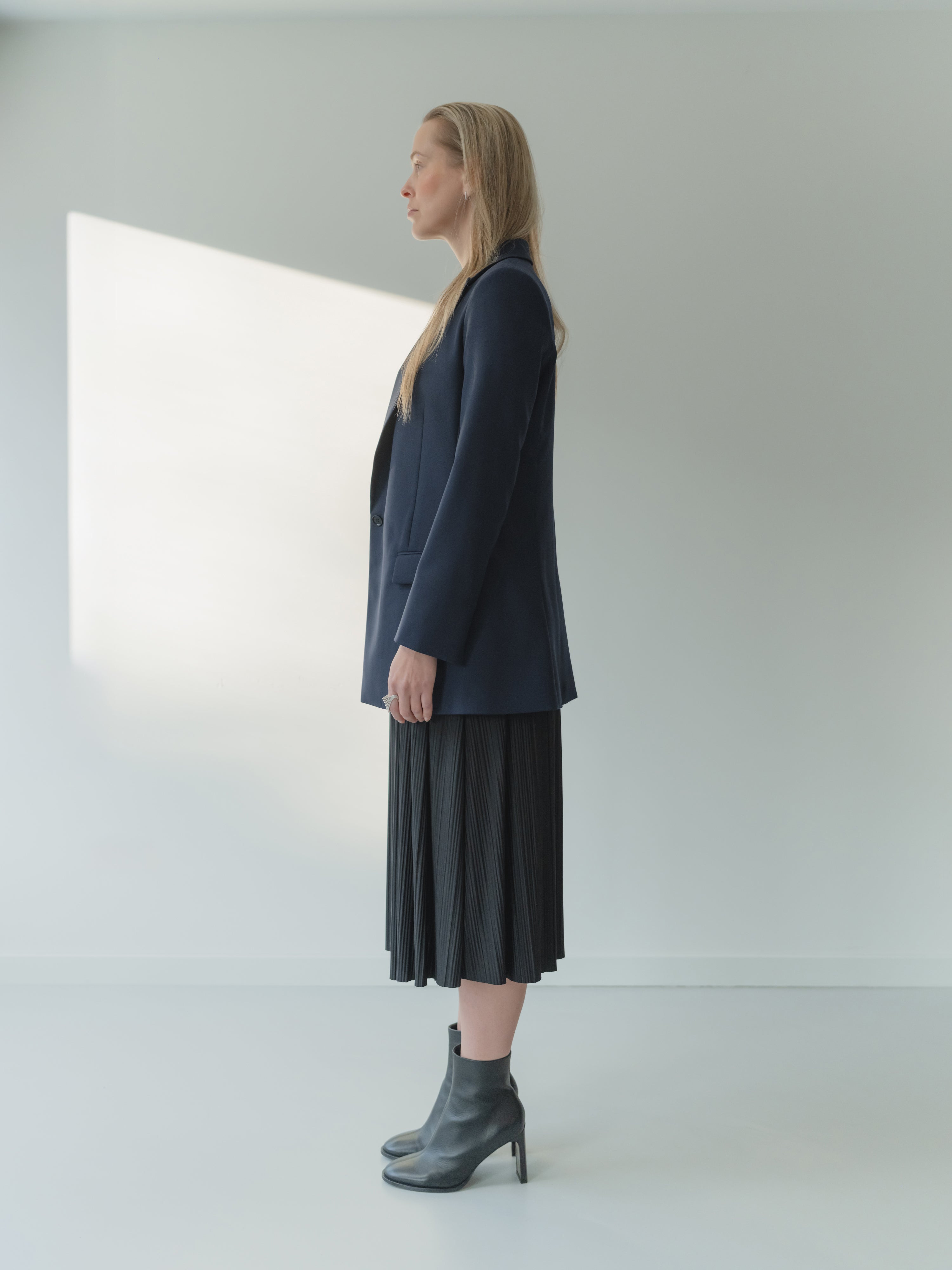 Navy single-breasted women’s peak lapel blazer in mid-weight stretch serge wool styled with a T-shirt and skirt.